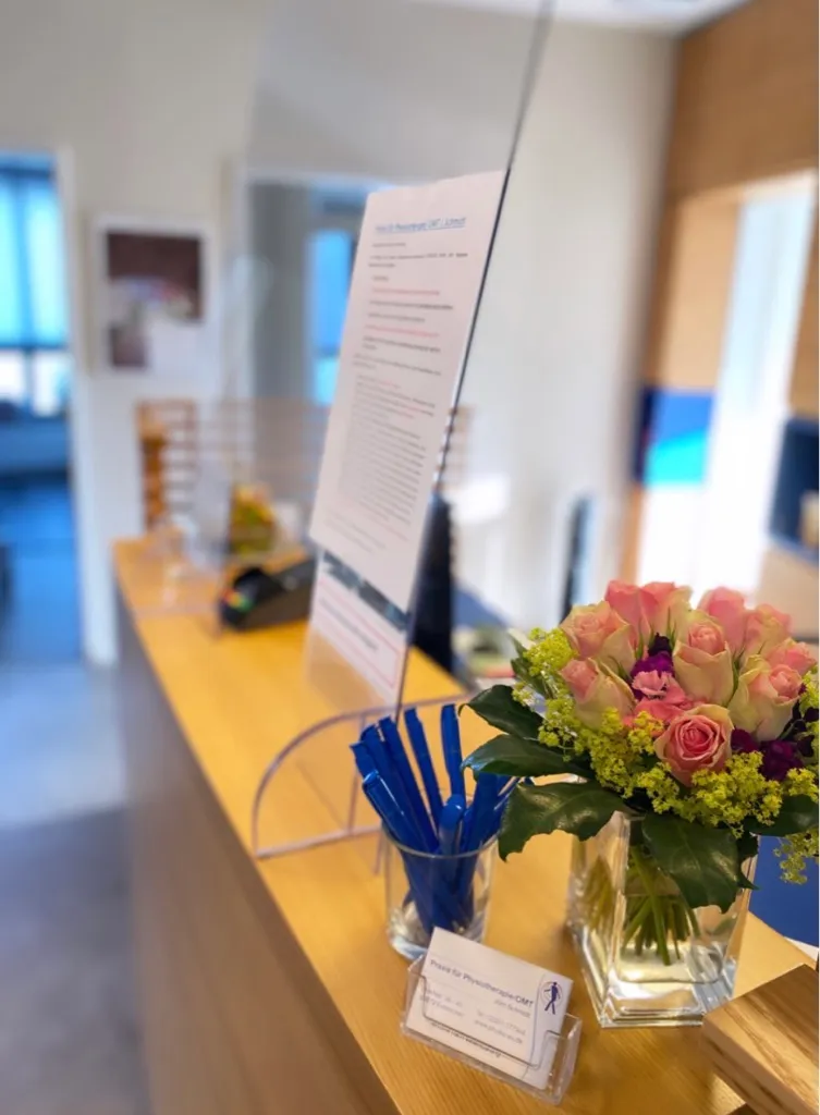 Empfangsbereich der Praxis mit Tresen und Blumen
