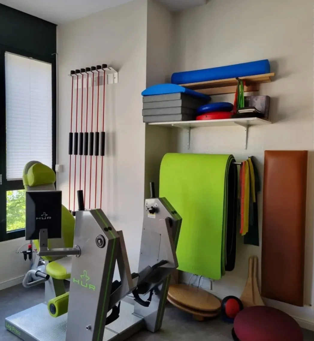 Trainingsraum der Praxis mit Leg Press, Therabändern und Kleingeräten